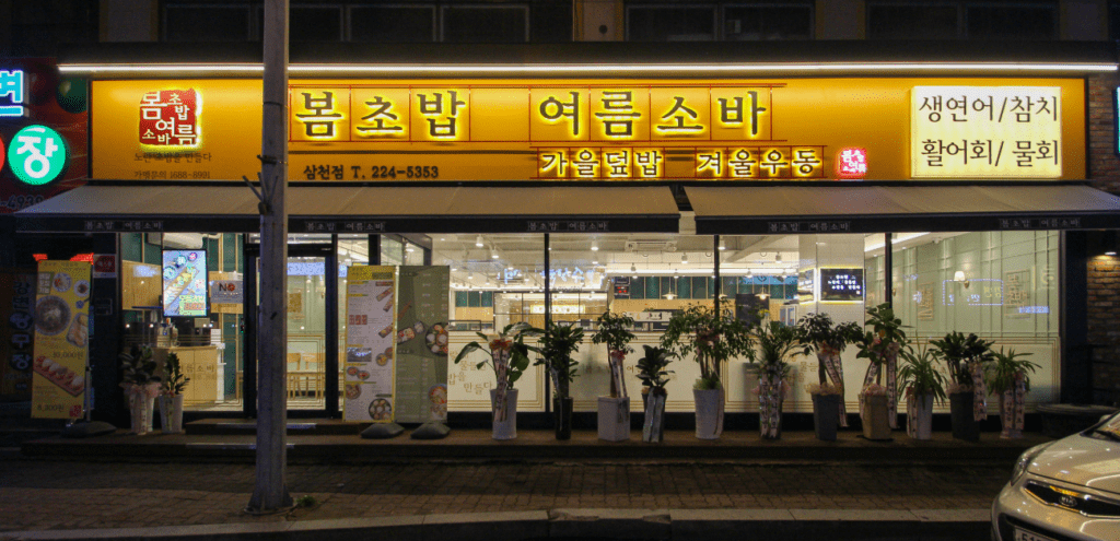 봄초밥여름소바 삼천점 외관 인테리어 – 야간 간판 조명과 전면 유리 파사드 시공